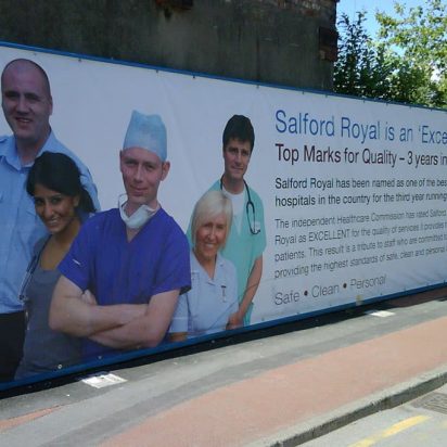 Digitally printed PVC banner promoting Salford Royal NHS hospital on a street billboard.