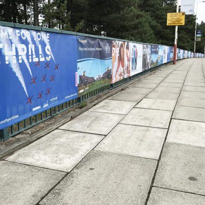 A fence in Southport covered in digitally printed assorted PVC banner advertisements.