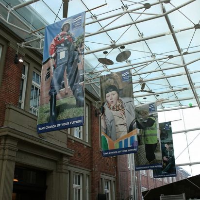 Southport College reception hall with double sided digitally printed hanging PVC banners, housed in a large building with a glass roof