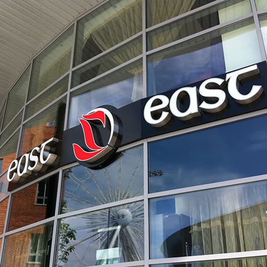 Built-up 3D stainless steel letters face lit banner Large sign on building side with illuminated 3D stainless steel letters spelling 'east Z east'
