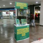 Promo stand advertising help for households scheme in a shopping centre