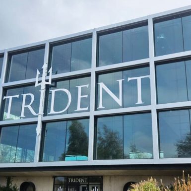 Trident Gym in Liverpool - white fret cut vinyl letters applied to window with aluminium composite letter mounted vertically to building frame