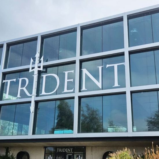 Trident Gym in Liverpool - white fret cut vinyl letters applied to window with aluminium composite letter mounted vertically to building frame